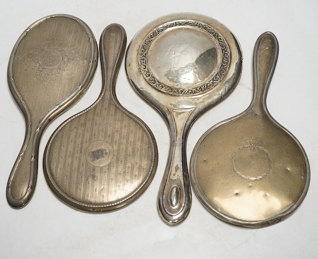 Four assorted silver mounted hand mirrors including London, 1907. Condition - poor to fair